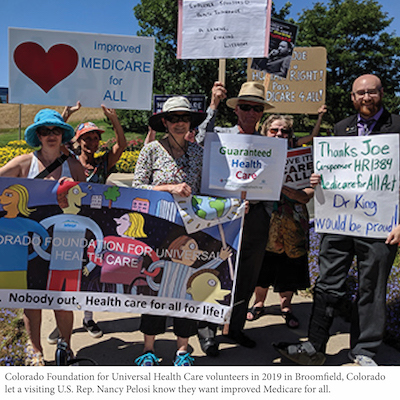 Smiling people hold signs for Improved medicare for All