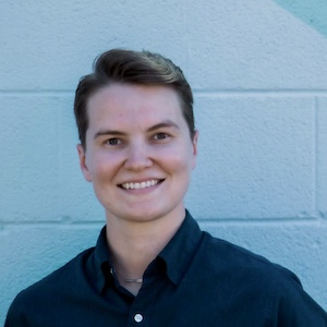 Kate Johnston, LCSW, smiles in front of a light-blue background