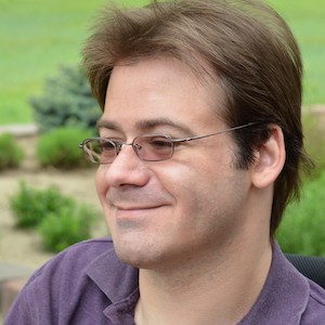 CO4UHC Board member Michael Neil smiles outside.